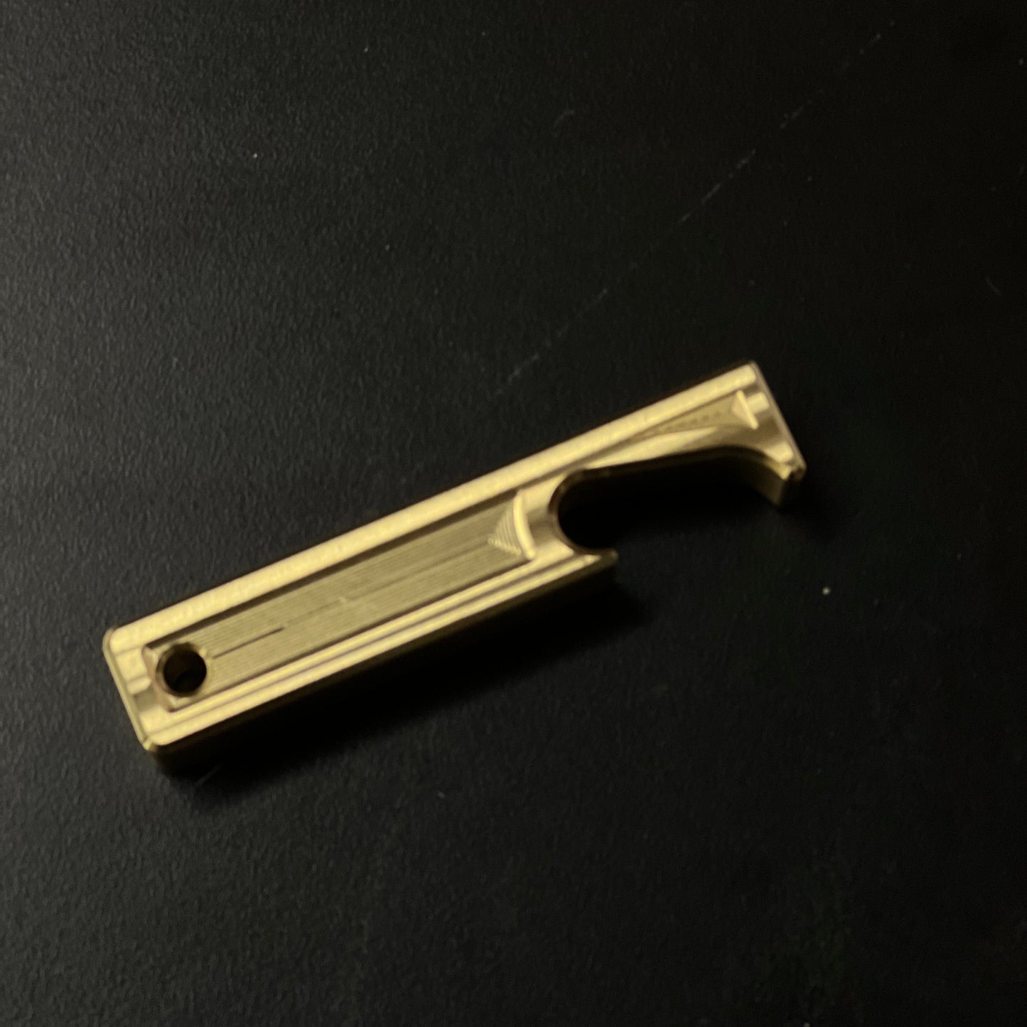 Brass bottle opener on a black background