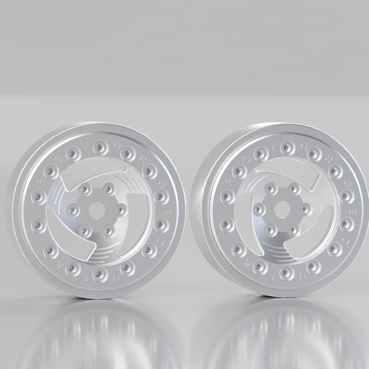 Two silver metallic wheel rims on a reflective gray surface