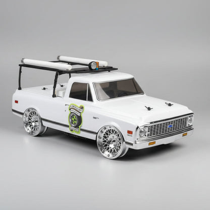 Model truck with roof rack on a wooden surface in a workshop setting