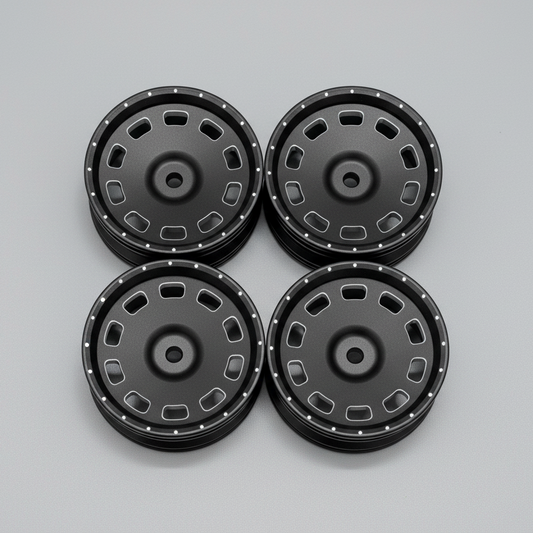 A set of four black anodized finish 1/10 scale drift wheels with a 12 mm hex size, displayed on a wooden surface.