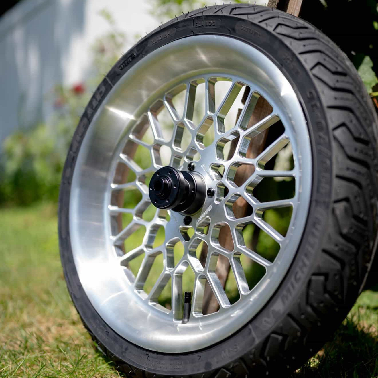 Close-up of a wheel with a silver rim on grass