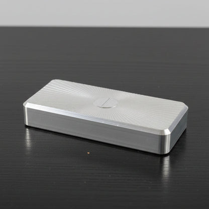 Metallic object on a black surface with 'DRINK NAP' text in the background
