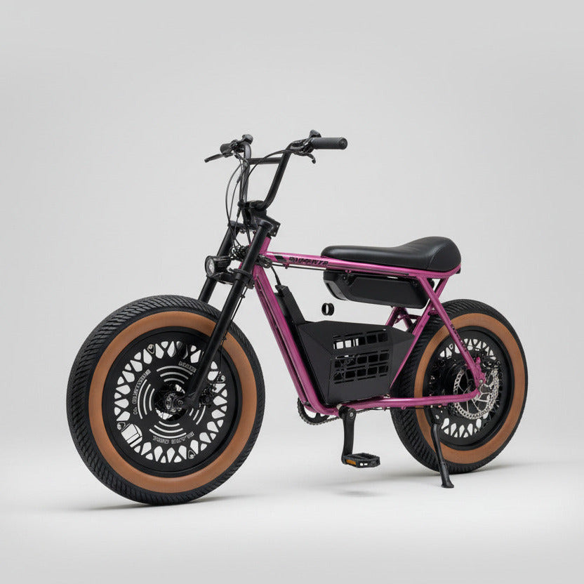 Purple electric bike with large wheels on a concrete surface, red garage door in the background