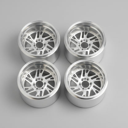 Four silver alloy wheels on a wooden surface