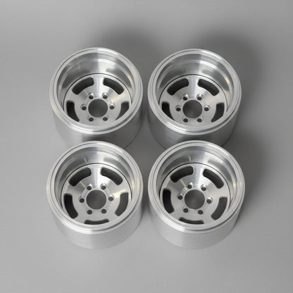 Four polished silver aluminum wheel rims arranged in a 2x2 grid on a gray concrete floor.