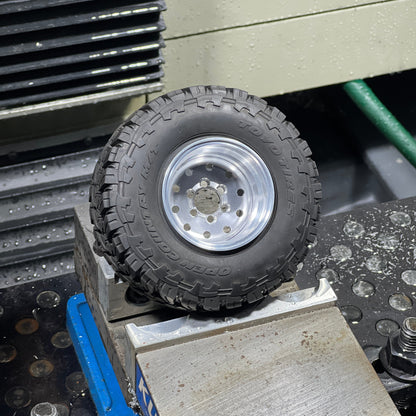 Close-up of a tire on a metal surface with tools and equipment in the background