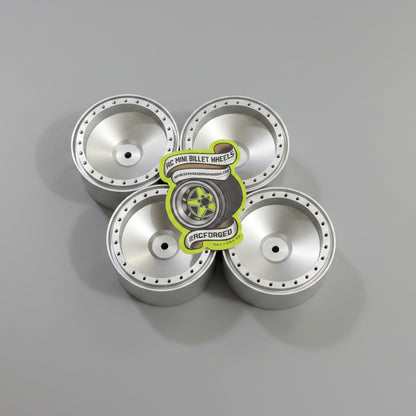 Five silver hubcaps on a dark wooden surface with a visible brand label.