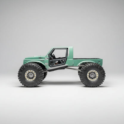 Model of a green off-road vehicle with large wheels on a textured surface.