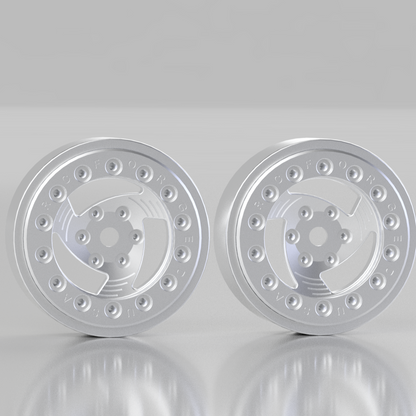 Two silver metallic wheel rims on a reflective gray surface