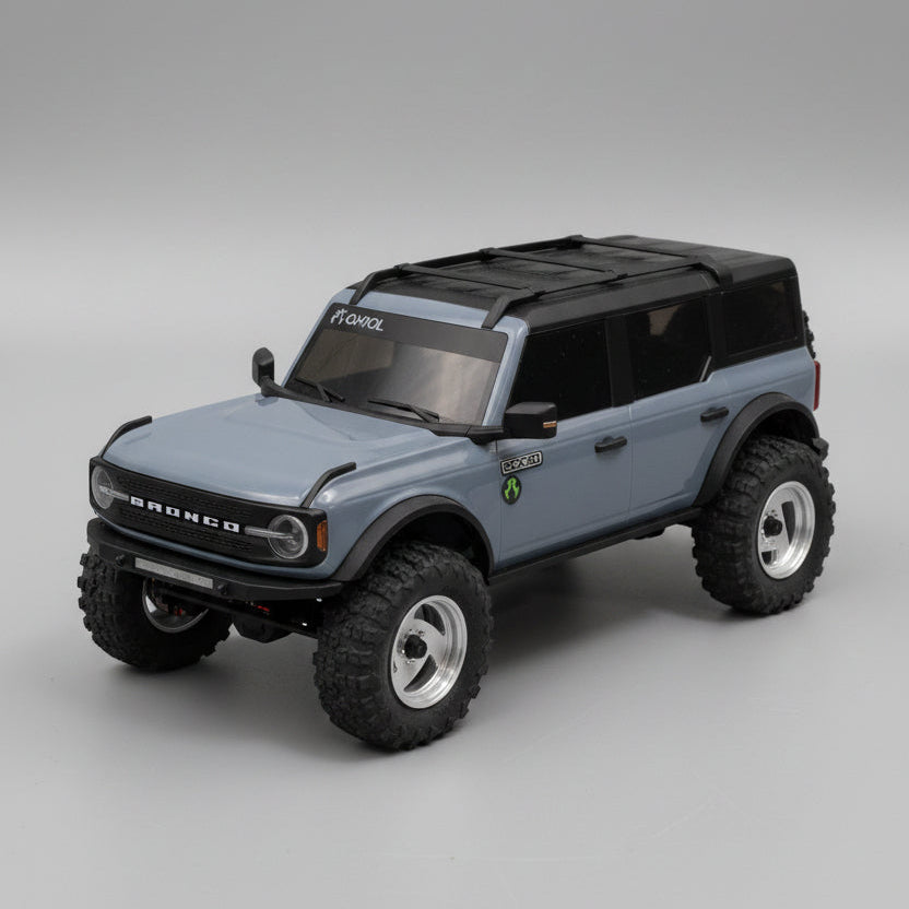 Model of a blue SUV with large wheels on a gray surface