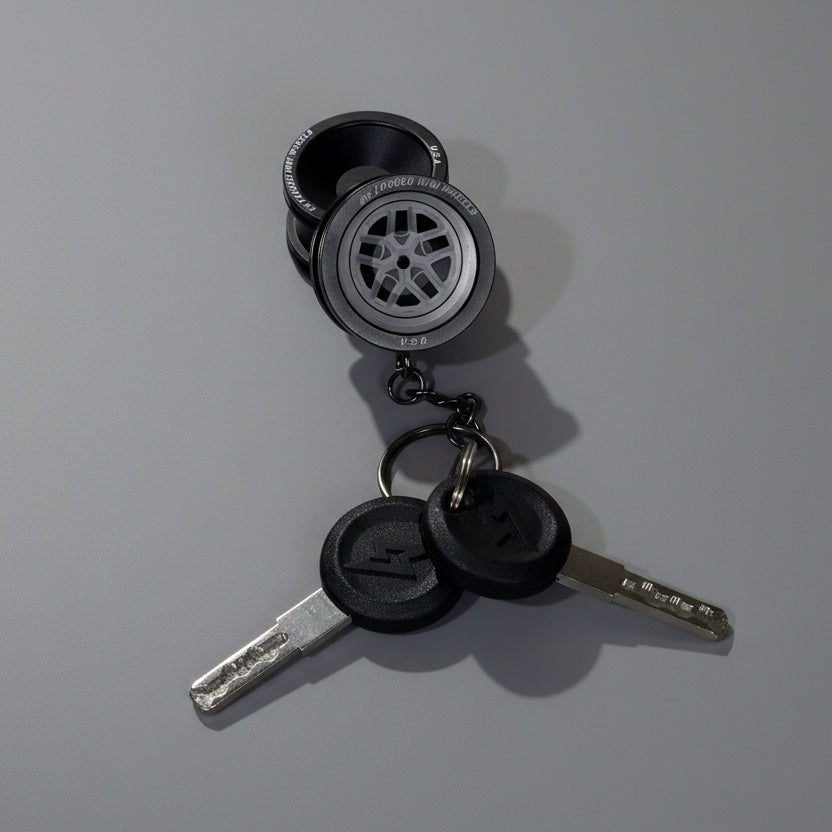 Keychain with tire and wheel design on a gray background
